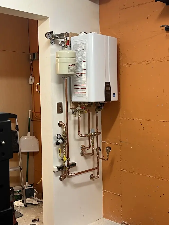 Plumbing technician inspecting water heater connections in Fair Lawn